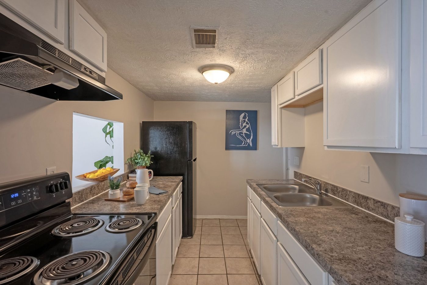 Renovated kitchen with white cabinets and updated counters at Grand Oaks